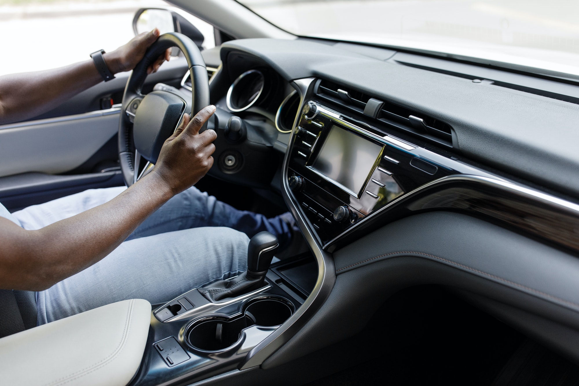 Closeup of black man hands driving luxury car